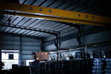 A large crane in a warehouse with lots of pallets