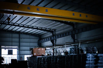 A large crane in a warehouse with lots of pallets