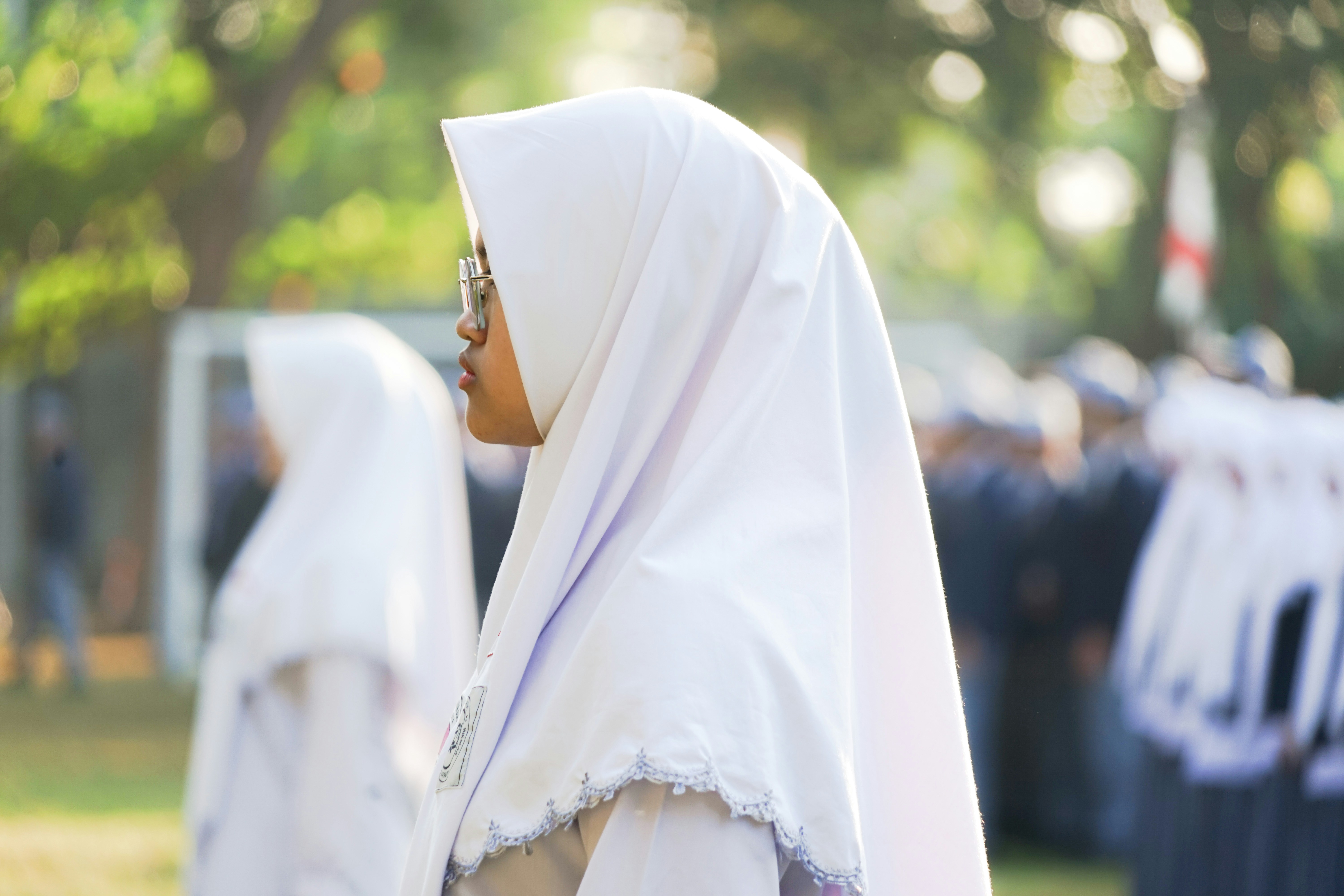 A woman in a white dress standing in front of other women