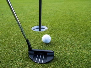 A golf putt and a golf ball on a putting green