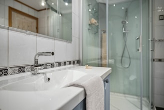 A bathroom with a walk in shower next to a sink