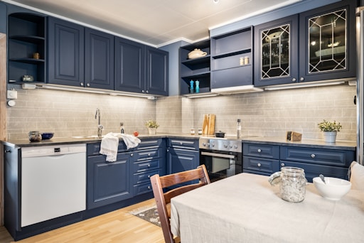 A kitchen with blue cabinets and a white table