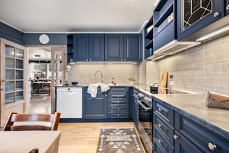 A kitchen with blue cabinets and white walls