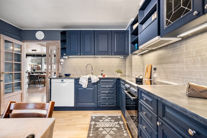 A kitchen with blue cabinets and white walls