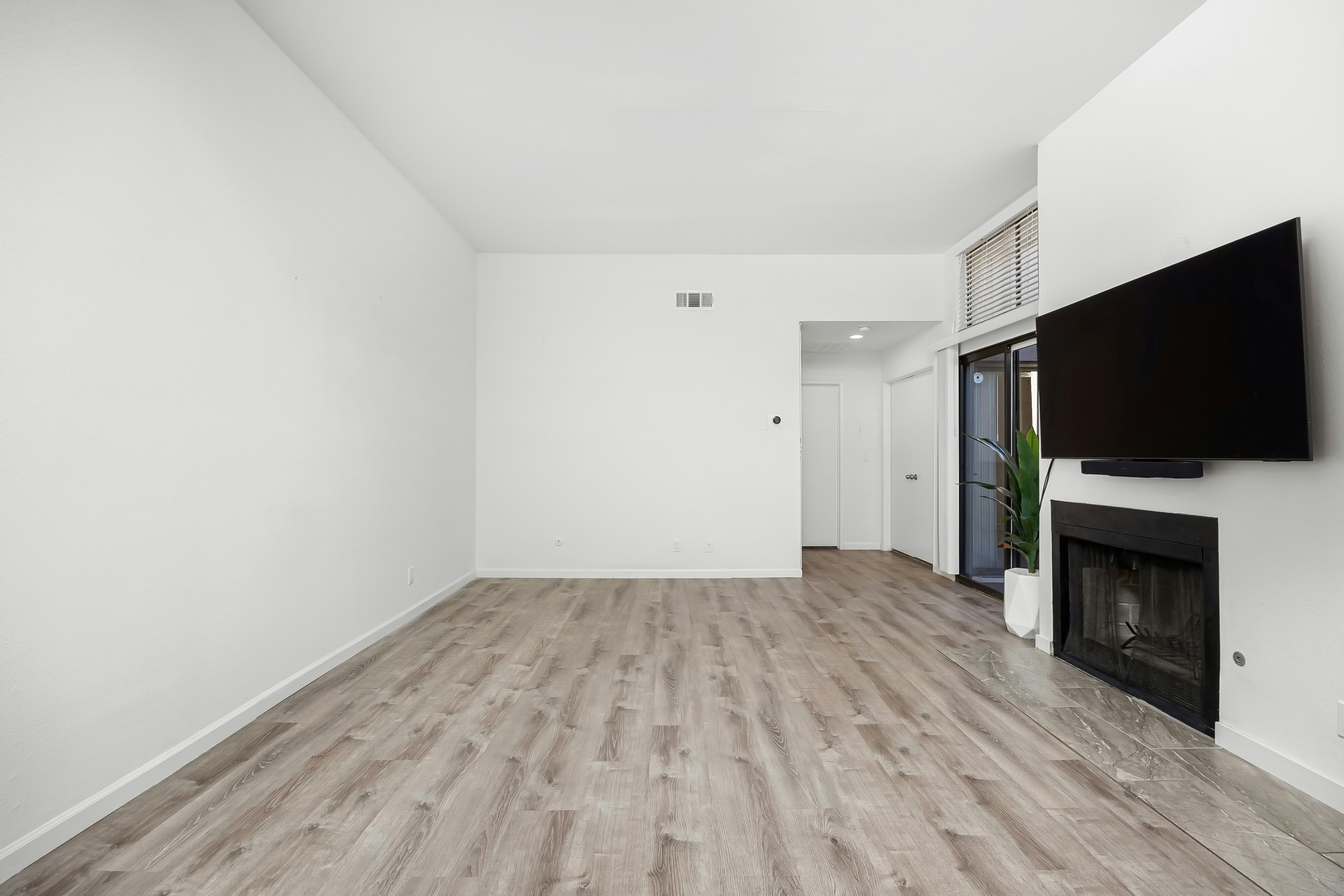 An empty room with a fireplace and a flat screen TV