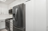 A kitchen with white cabinets and stainless steel appliances