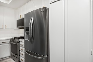 A kitchen with white cabinets and stainless steel appliances