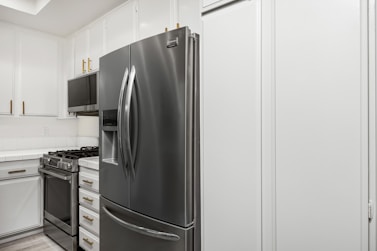 A kitchen with white cabinets and stainless steel appliances