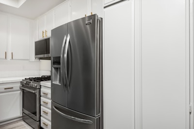 A kitchen with white cabinets and stainless steel appliances