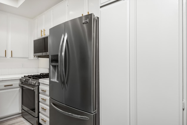 A kitchen with white cabinets and stainless steel appliances