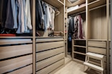 A walk in closet filled with lots of clothes