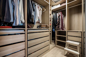 A walk in closet filled with lots of clothes