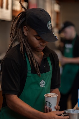 A man with dreadlocks holding a cup of coffee