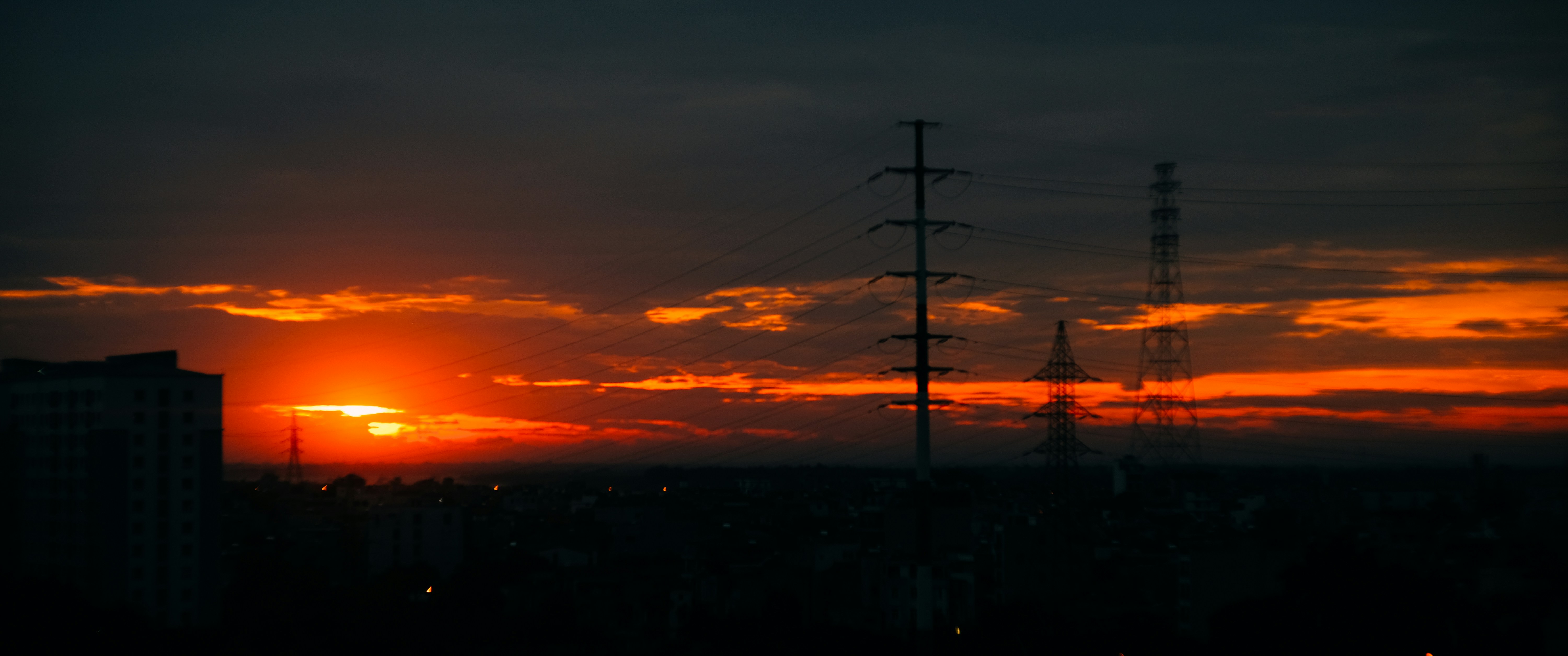 The sun is setting over a city with tall buildings