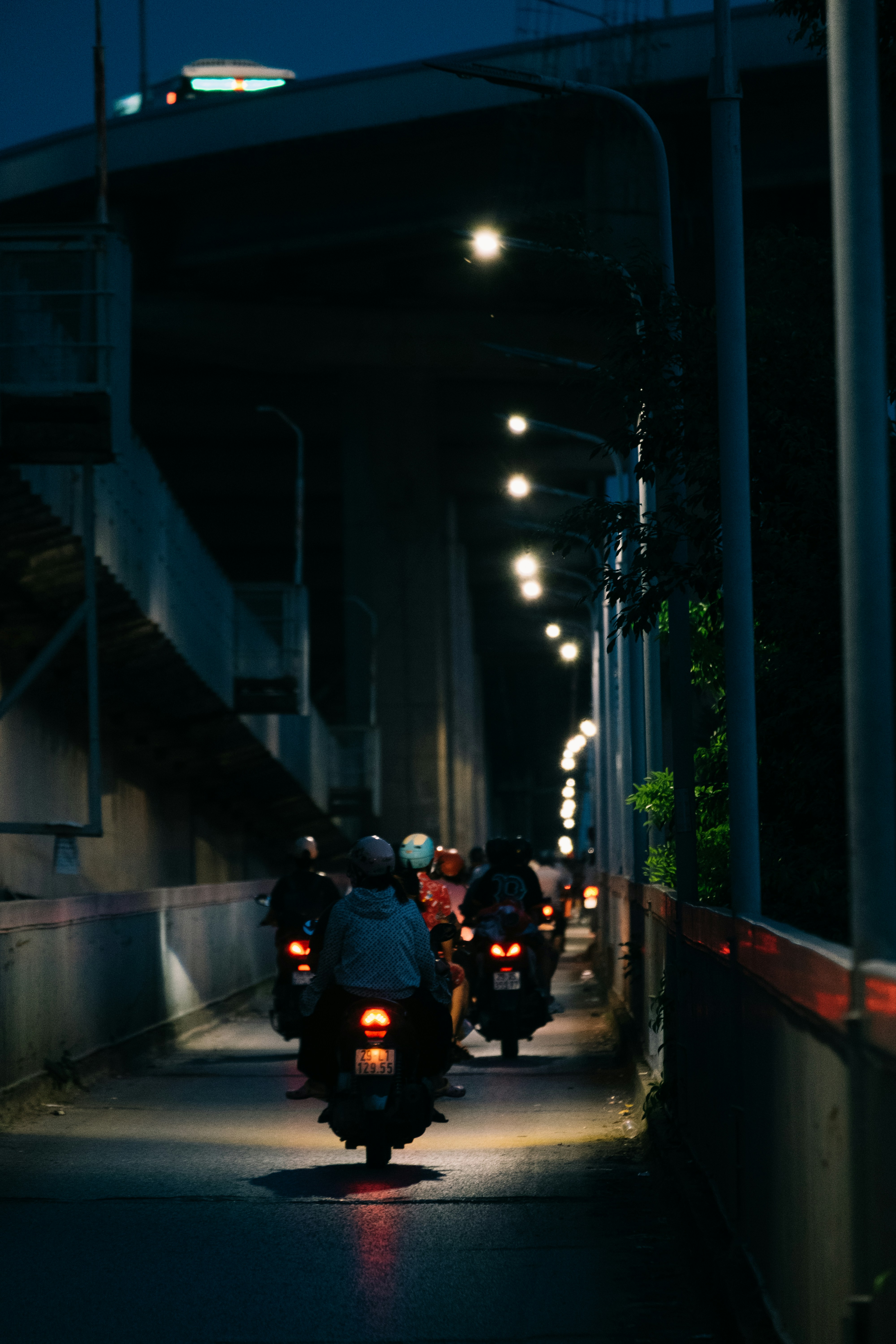 A group of people riding motorcycles down a street