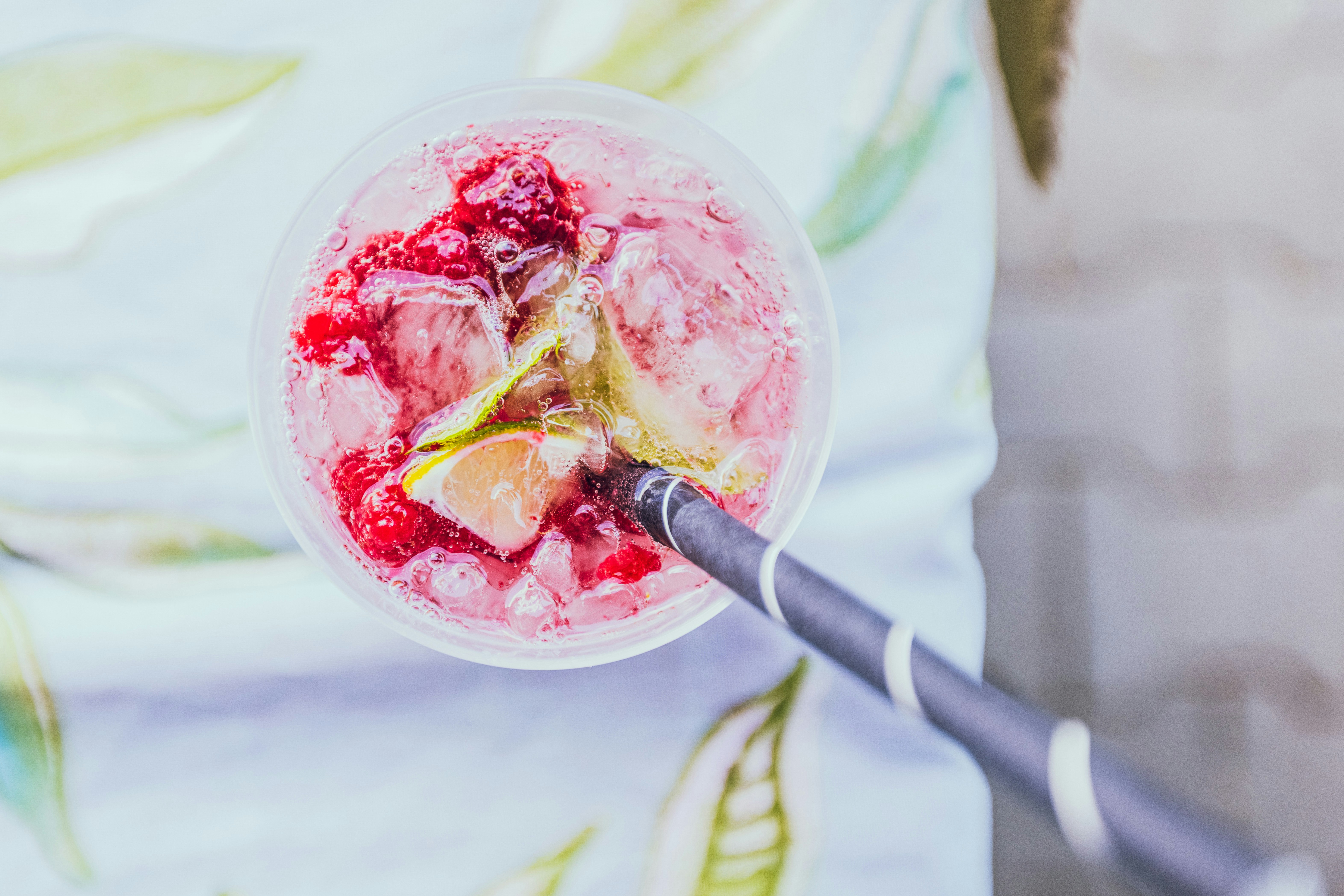 A person holding a drink with a straw in it