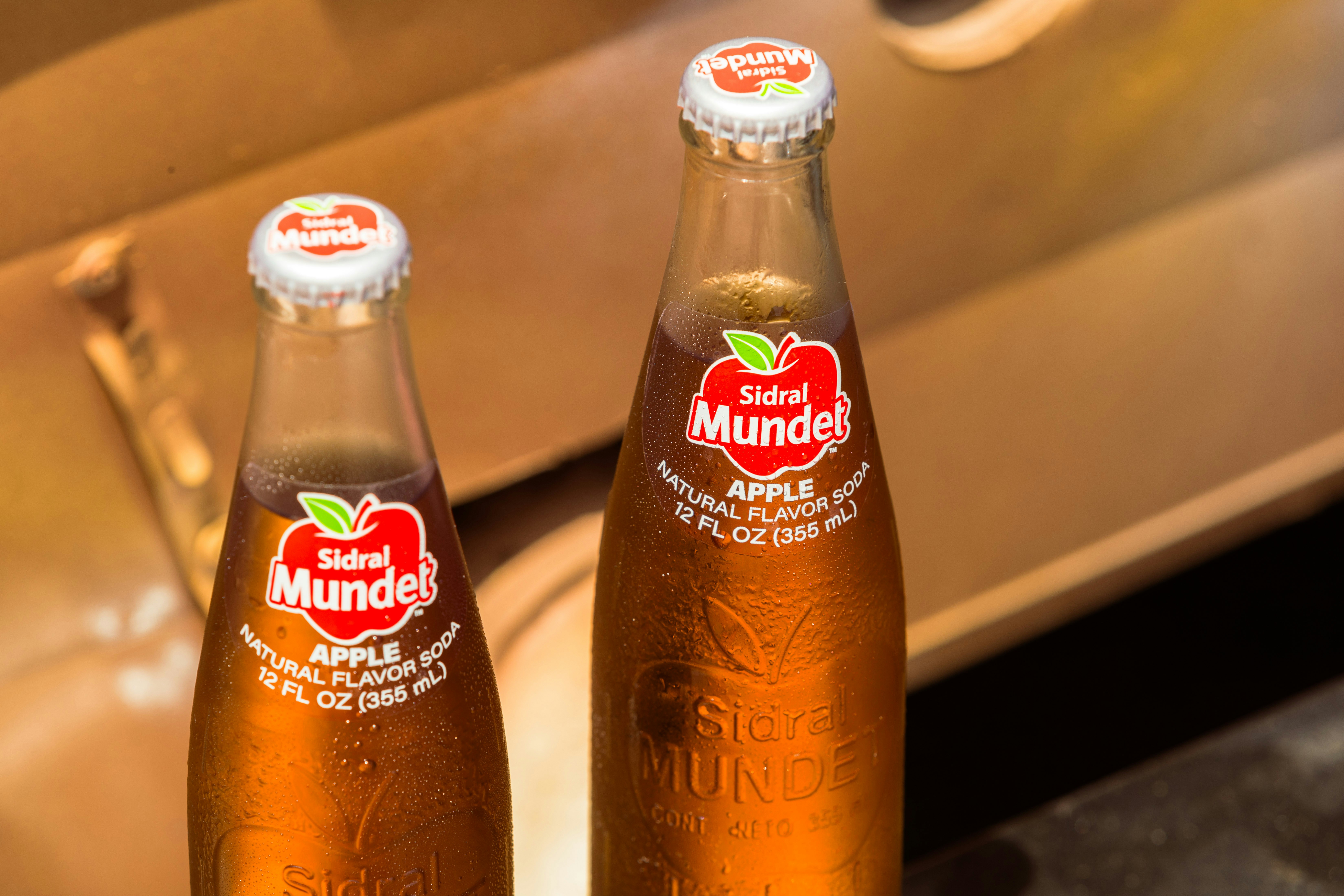Two bottles of apple juice sitting on a counter