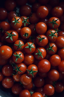 A bunch of tomatoes are in a bowl