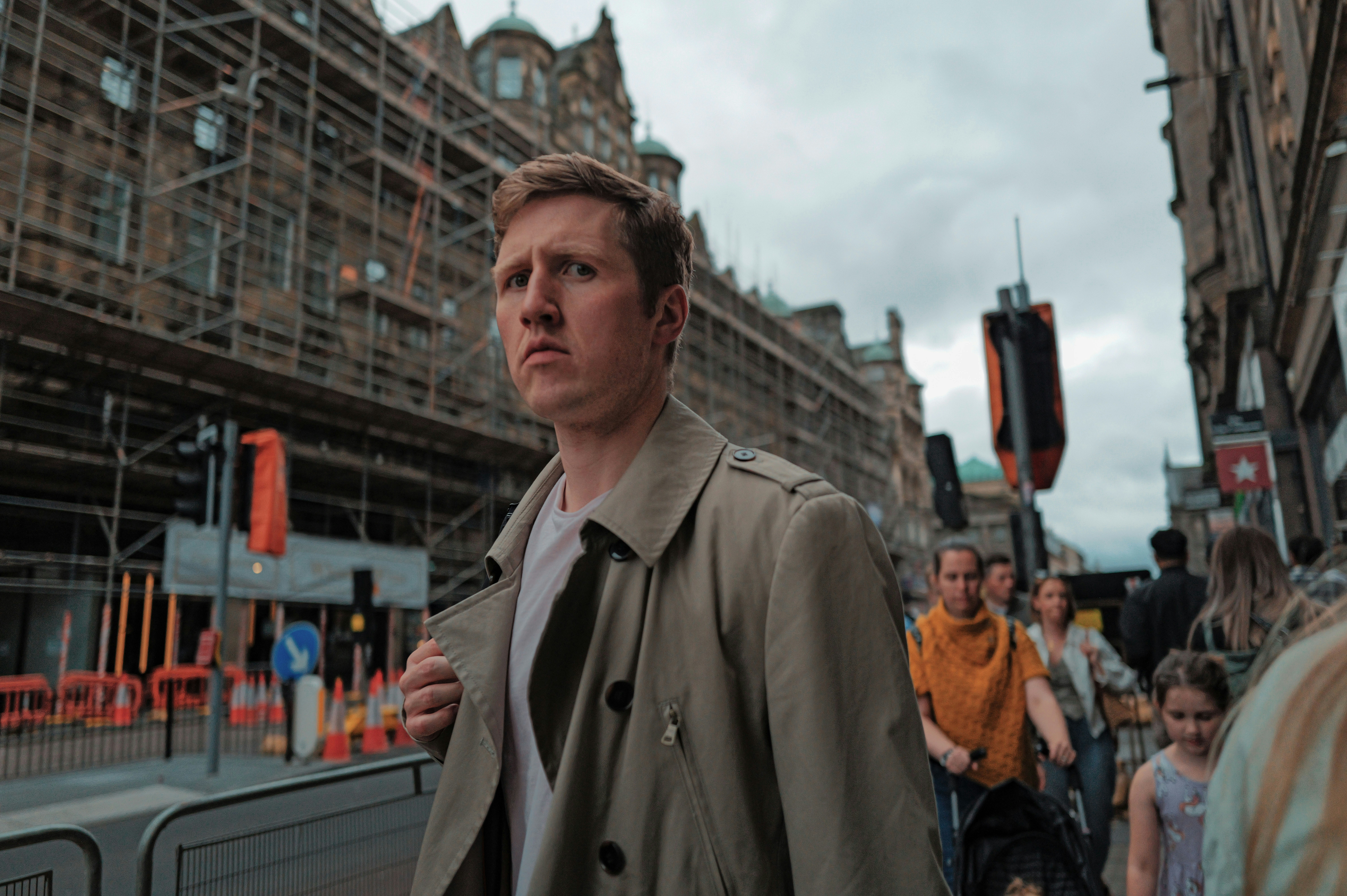 Un homme en trench-coat marchant dans la rue