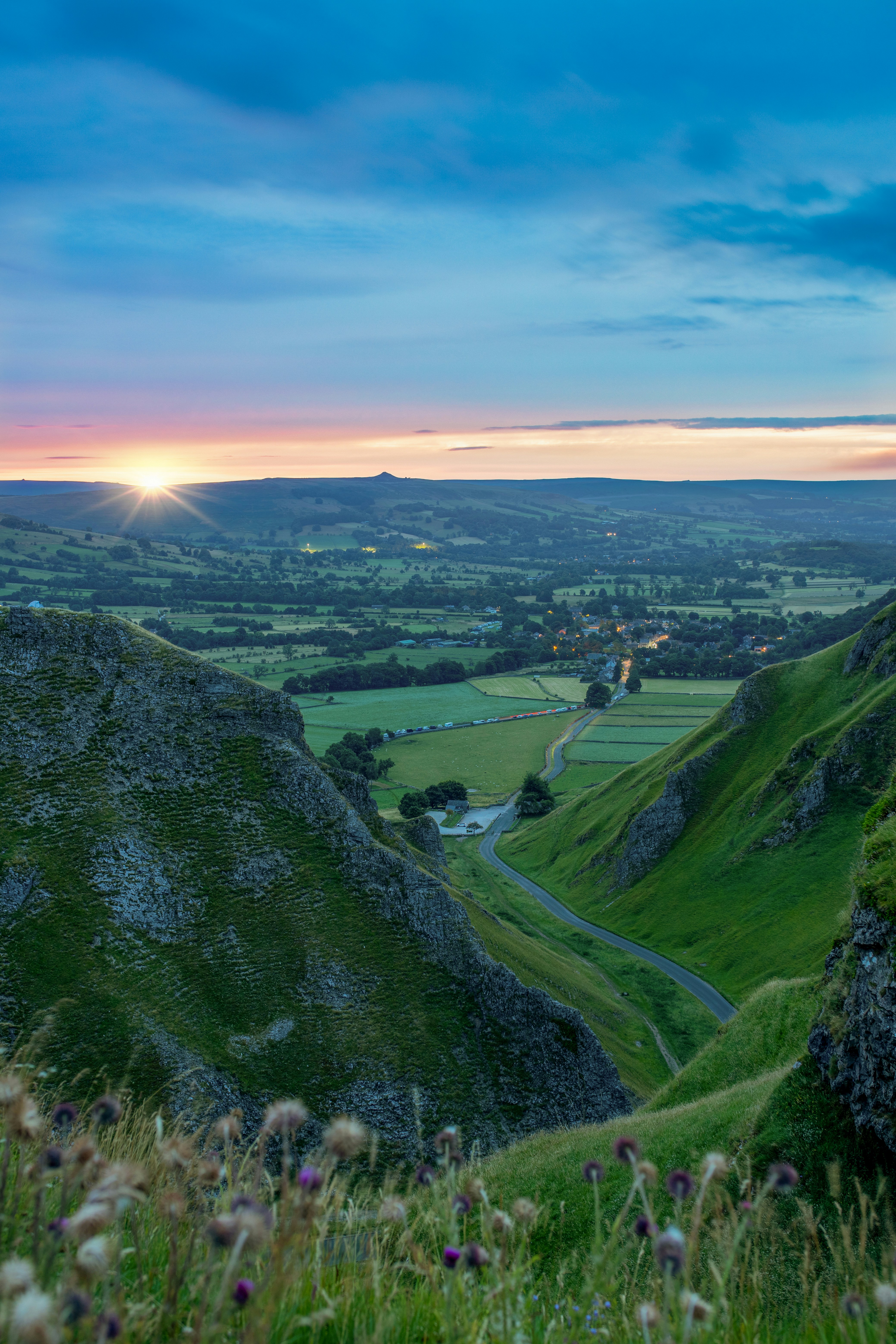 The sun is setting over a valley in the countryside
