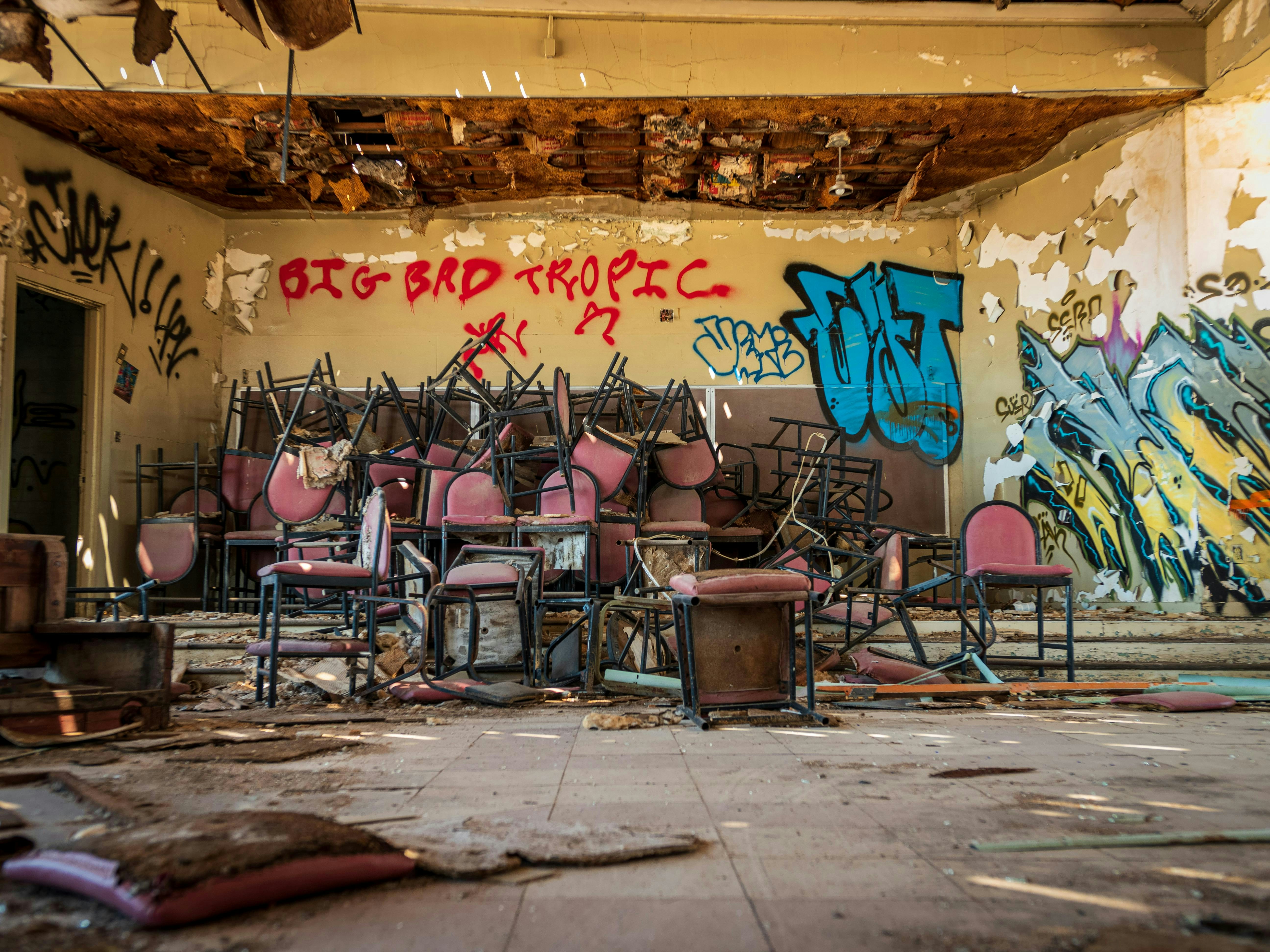 A room with a bunch of chairs and graffiti on the walls