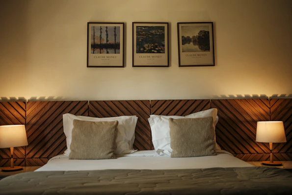 A bed with two lamps on either side of it