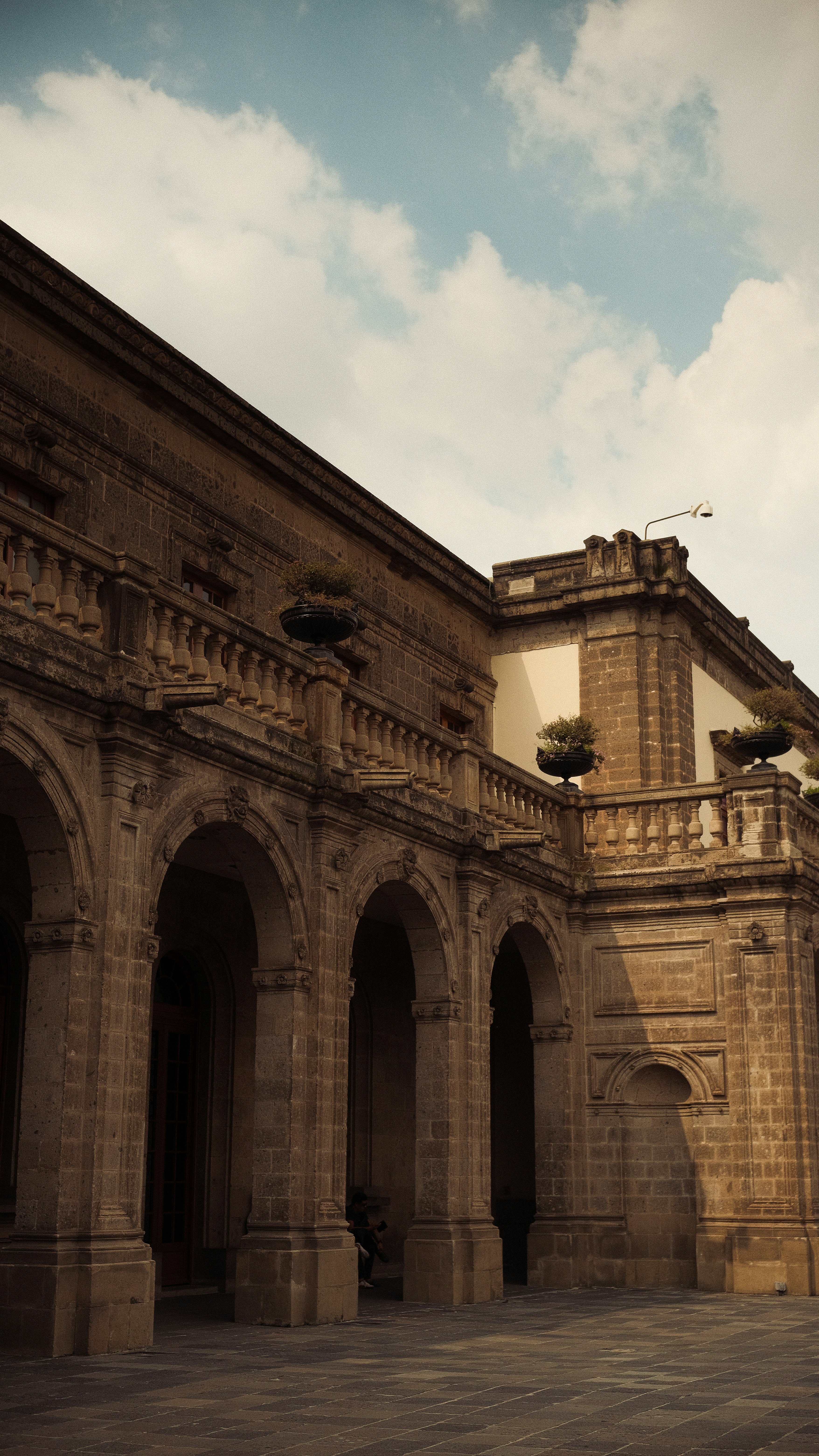 A man riding a skateboard down a street next to a tall building