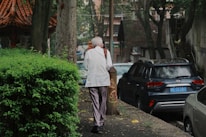 A man walking down a street next to parked cars