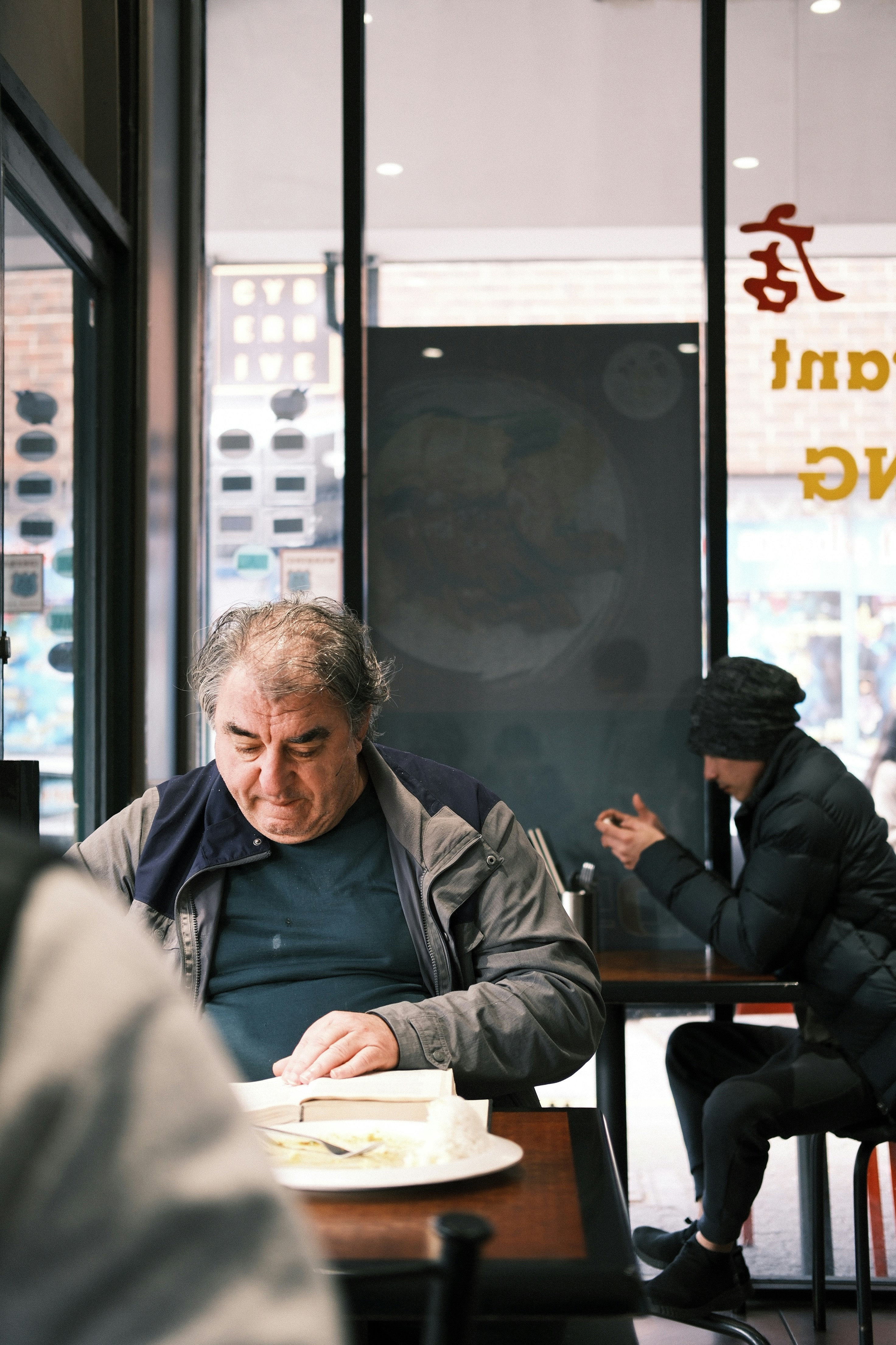 A man sitting at a table with a book in front of him