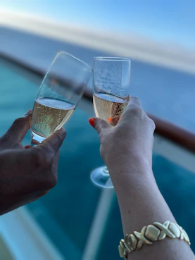A couple of people that are holding wine glasses