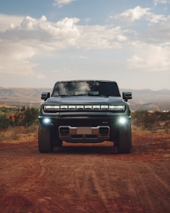 A pick up truck driving down a dirt road