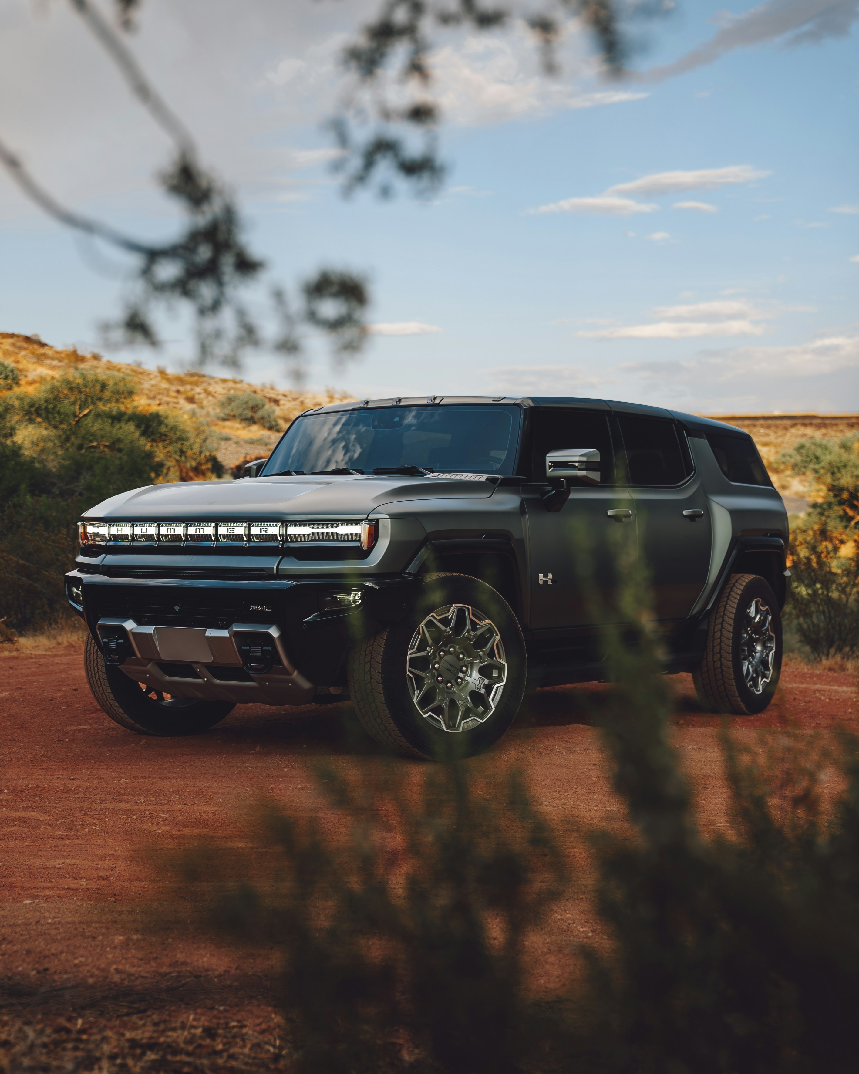 A silver truck parked on a dirt road