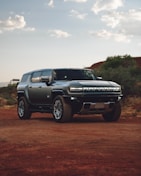 A silver truck parked on a dirt road