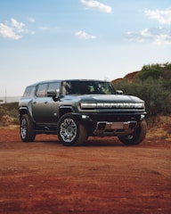 A silver truck parked on a dirt road
