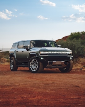 A silver truck parked on a dirt road