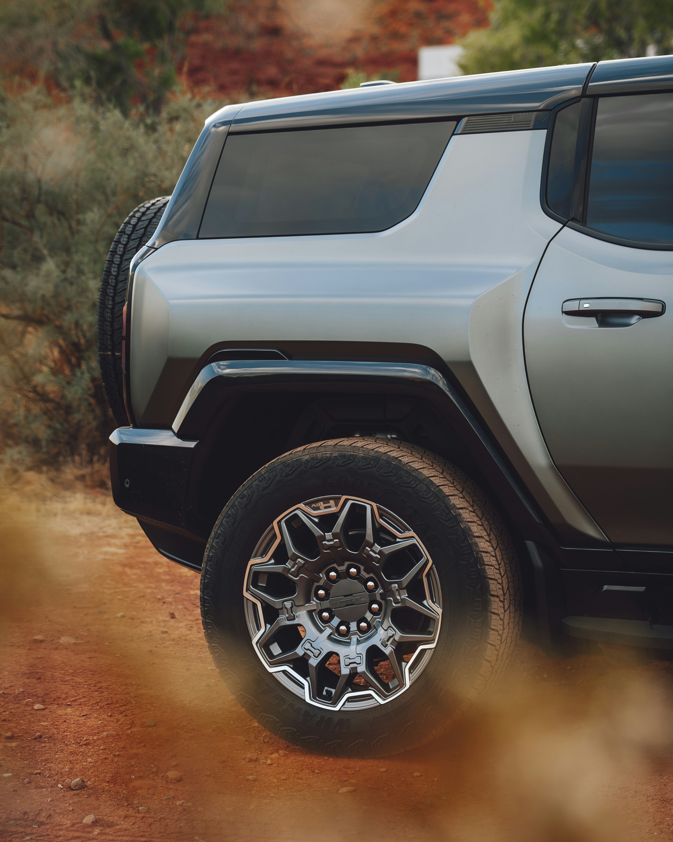A grey jeep parked on a dirt road
