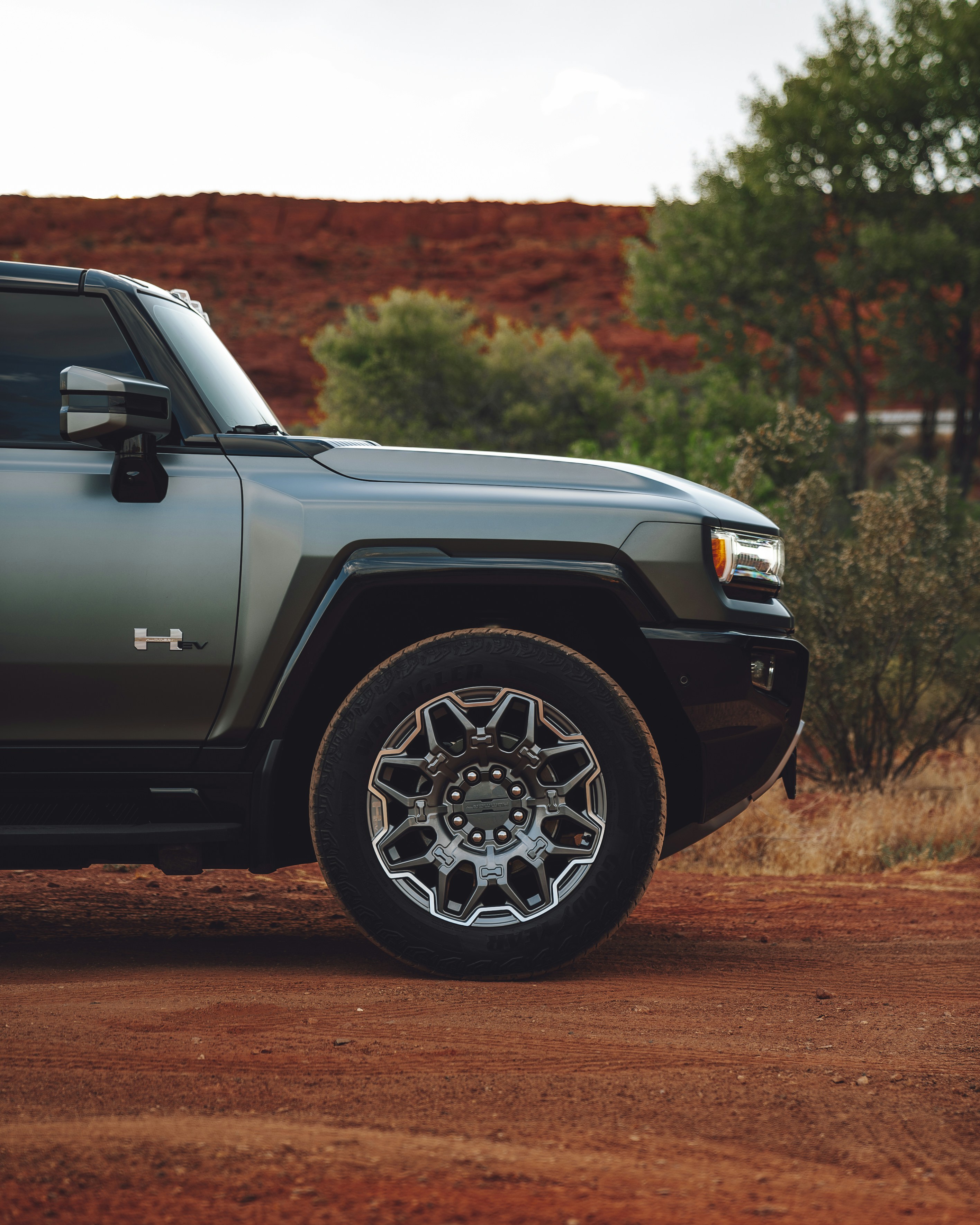 A green truck parked on a dirt road
