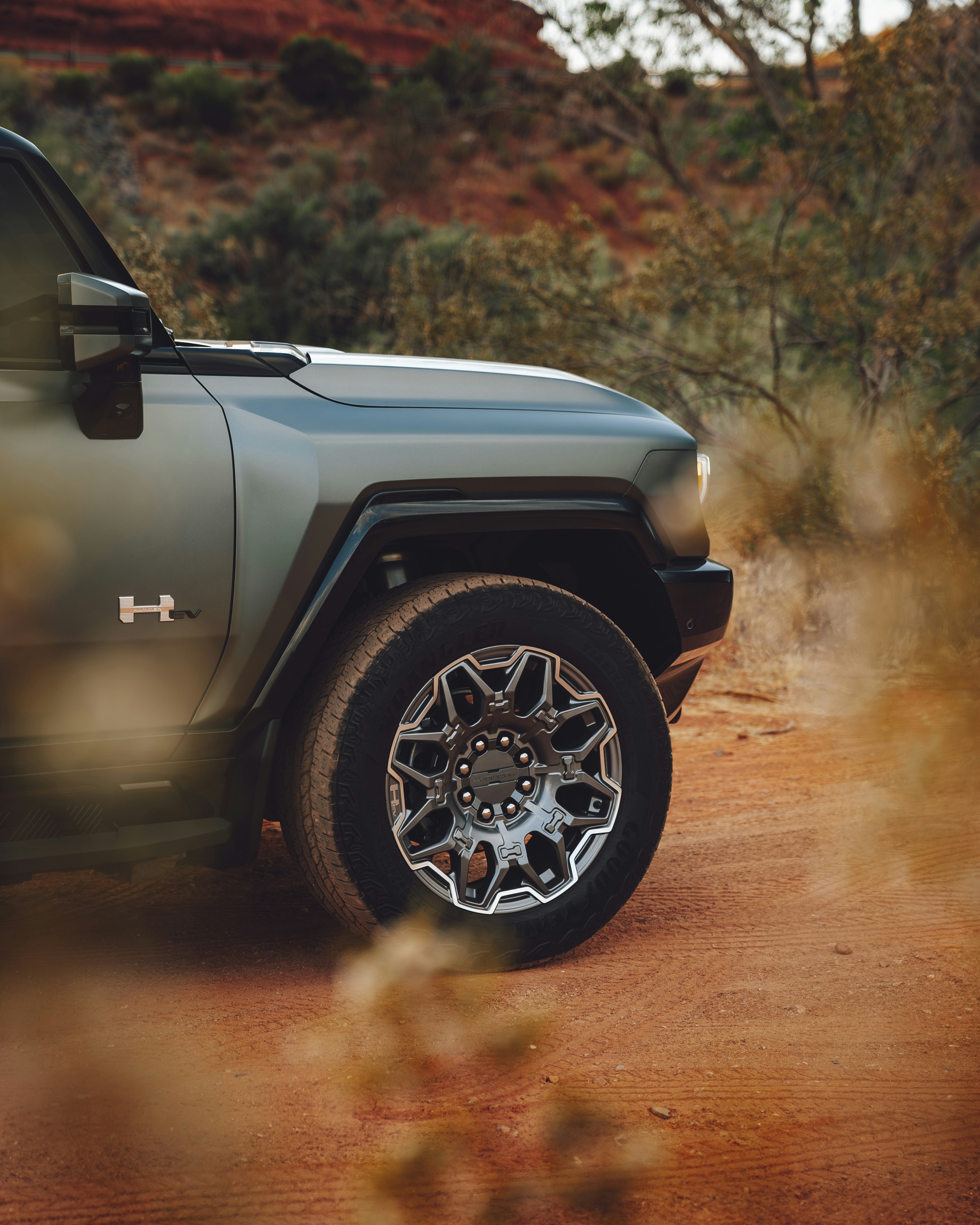 A green jeep parked on a dirt road