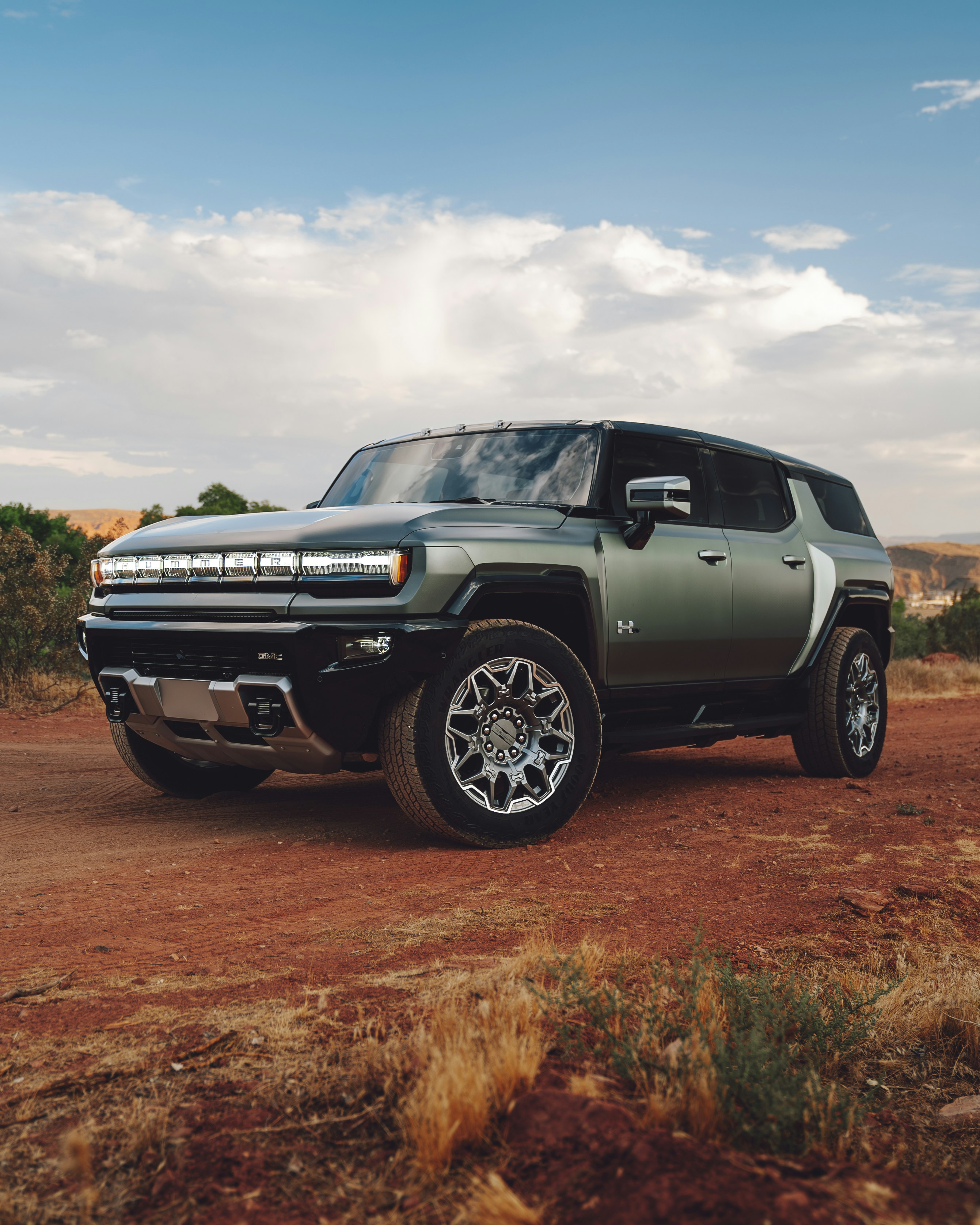 A green truck parked on a dirt road