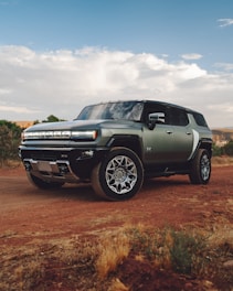 A green truck parked on a dirt road