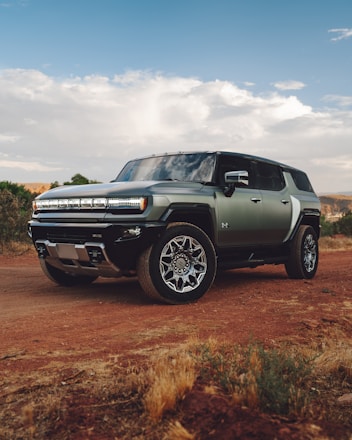A green truck parked on a dirt road