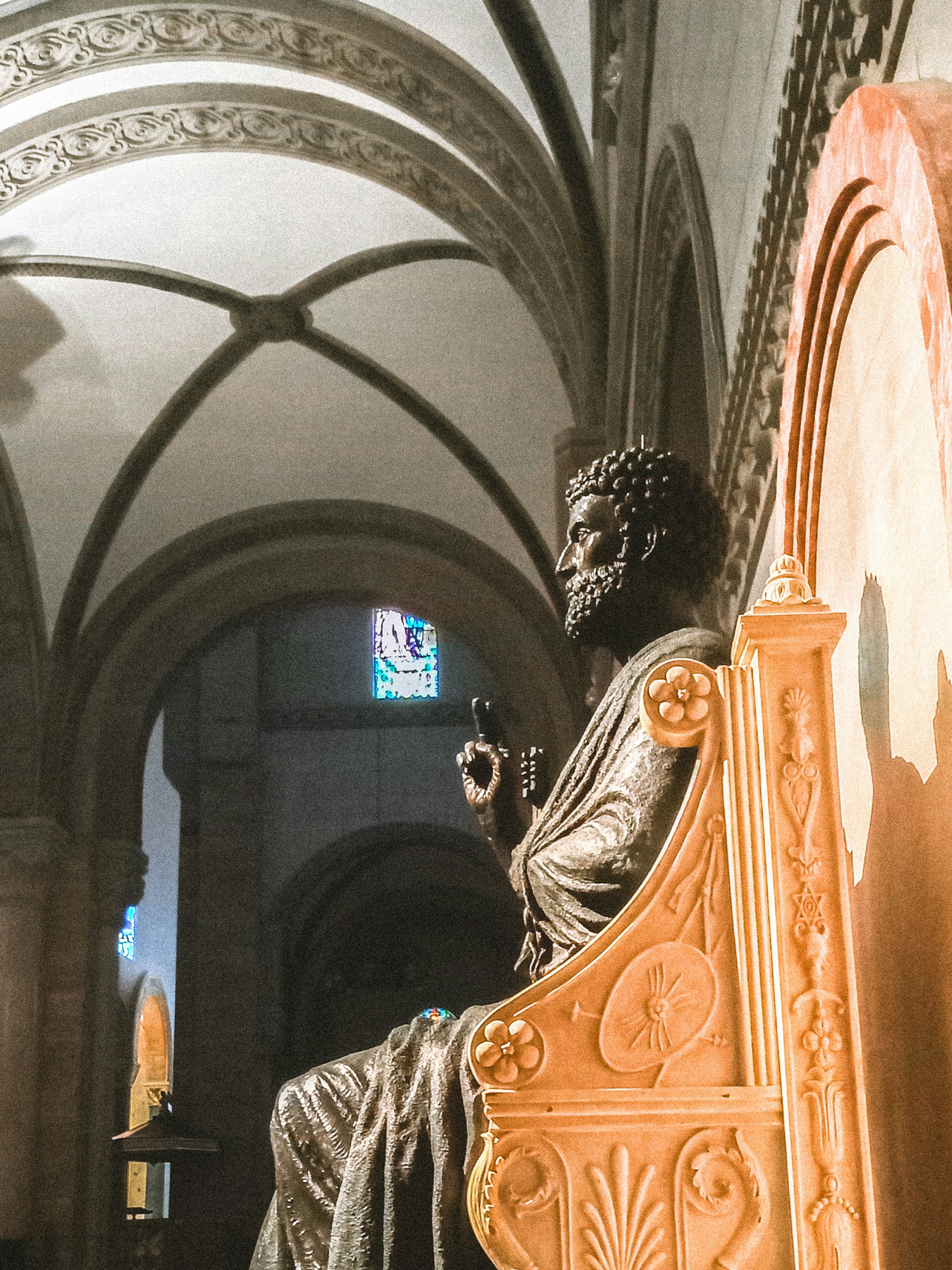 A statue of a man sitting on top of a bench
