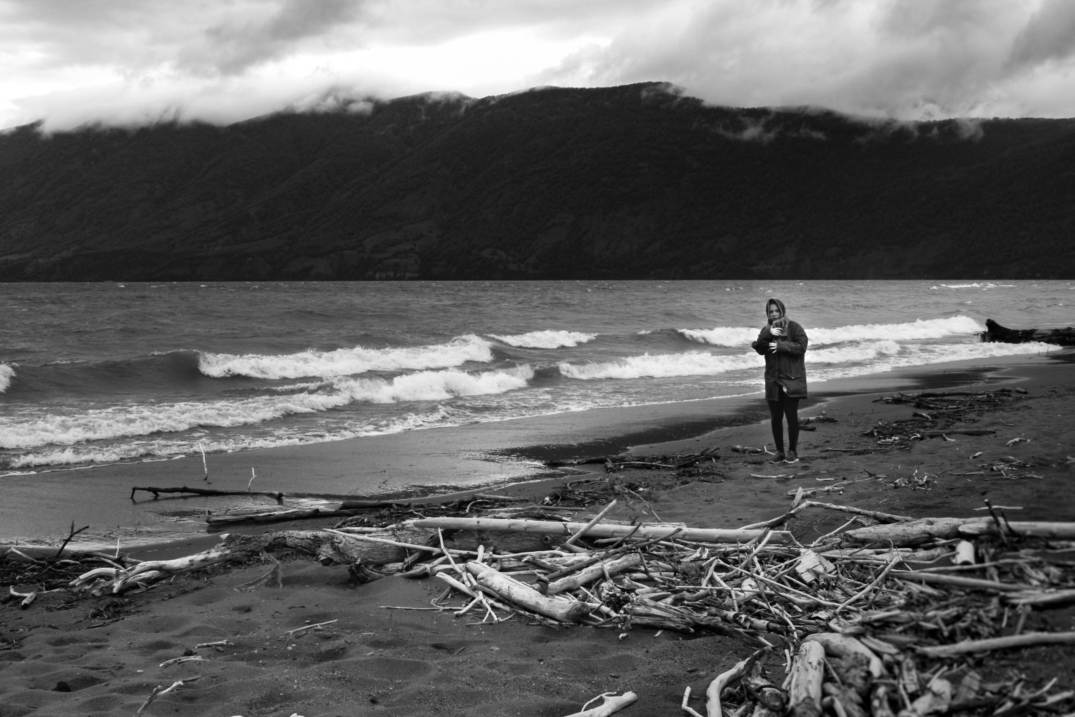 A man standing on a beach next to the ocean