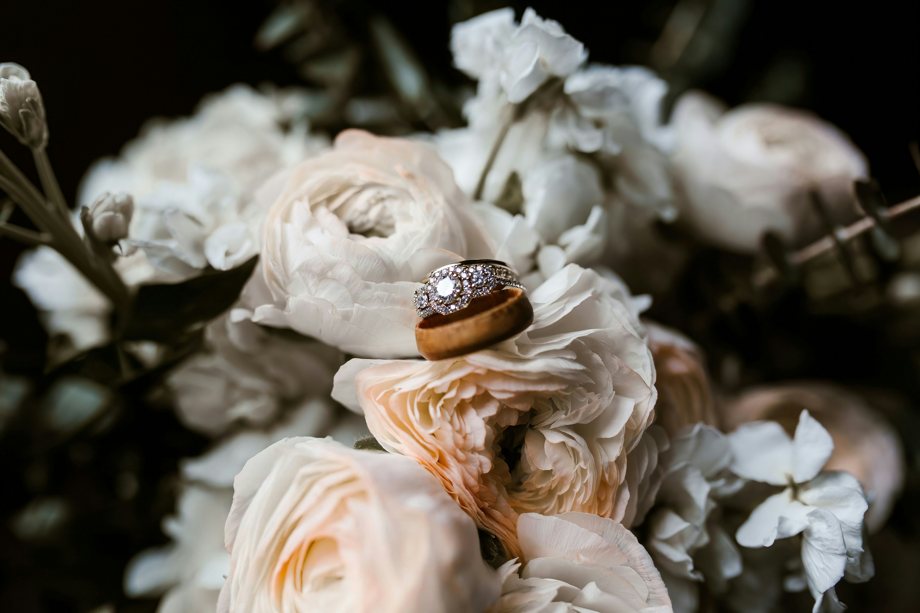 A close up of a bouquet of flowers with a wedding ring