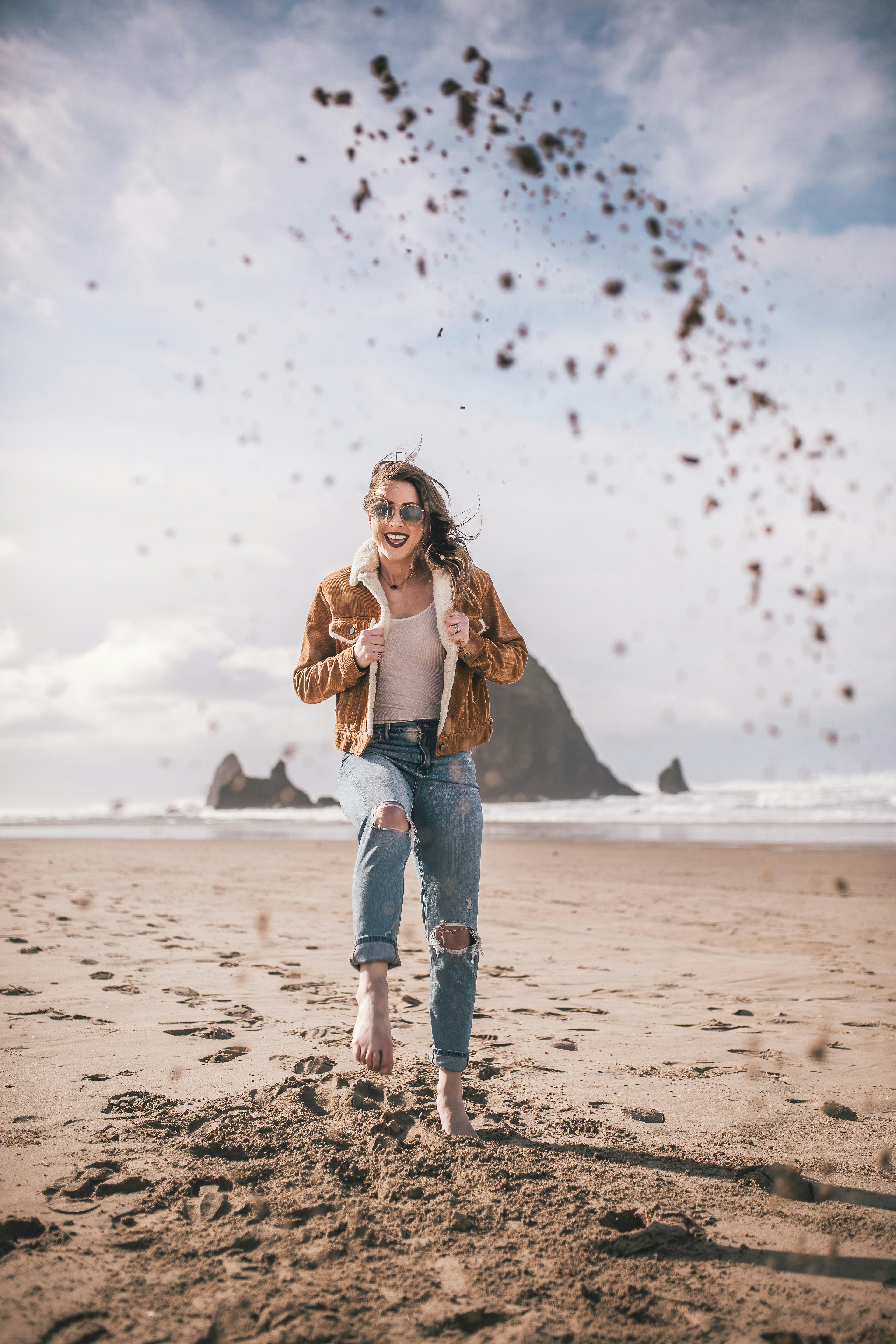 A woman standing on top of a sandy beach