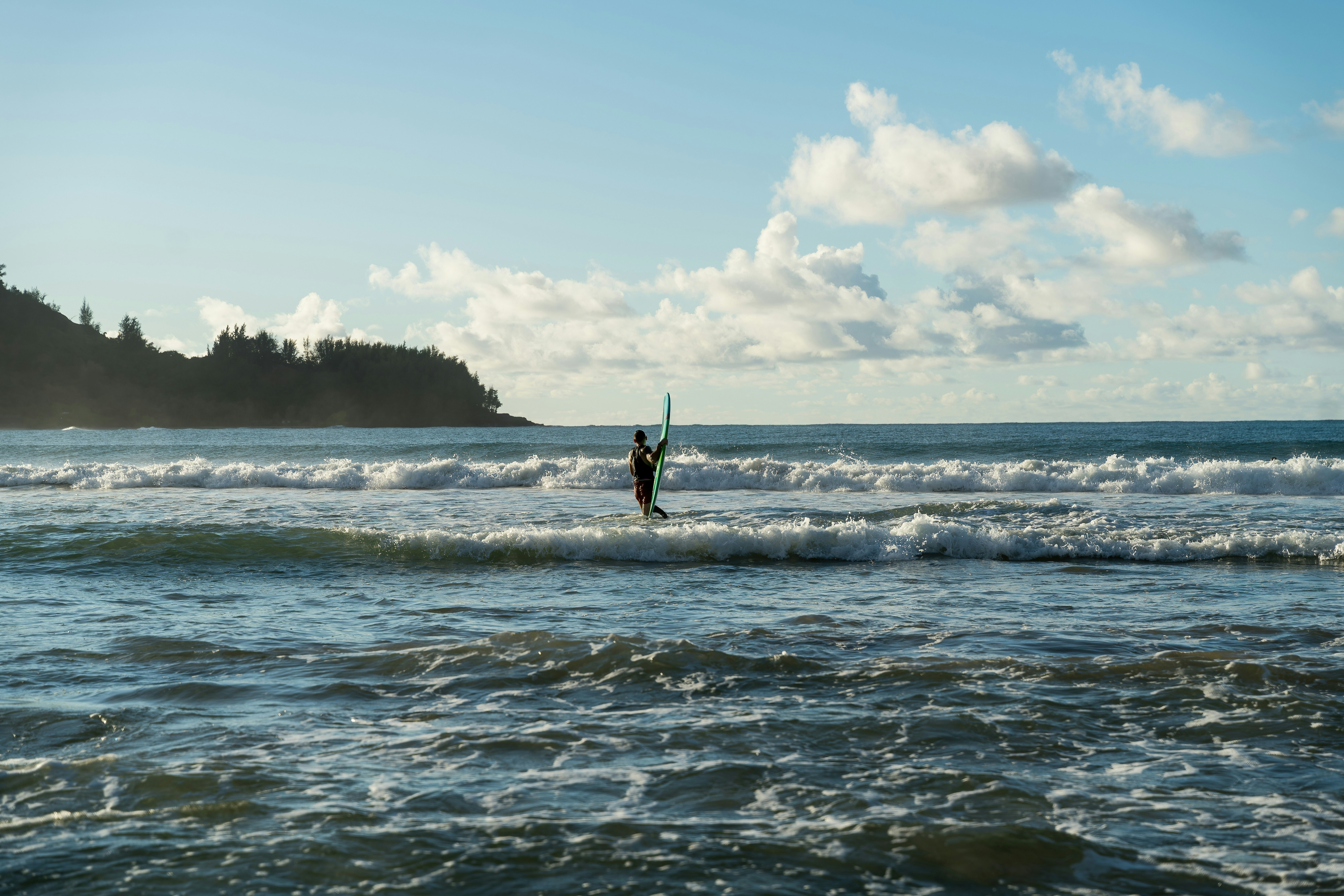 A person riding a surfboard on a wave in the ocean