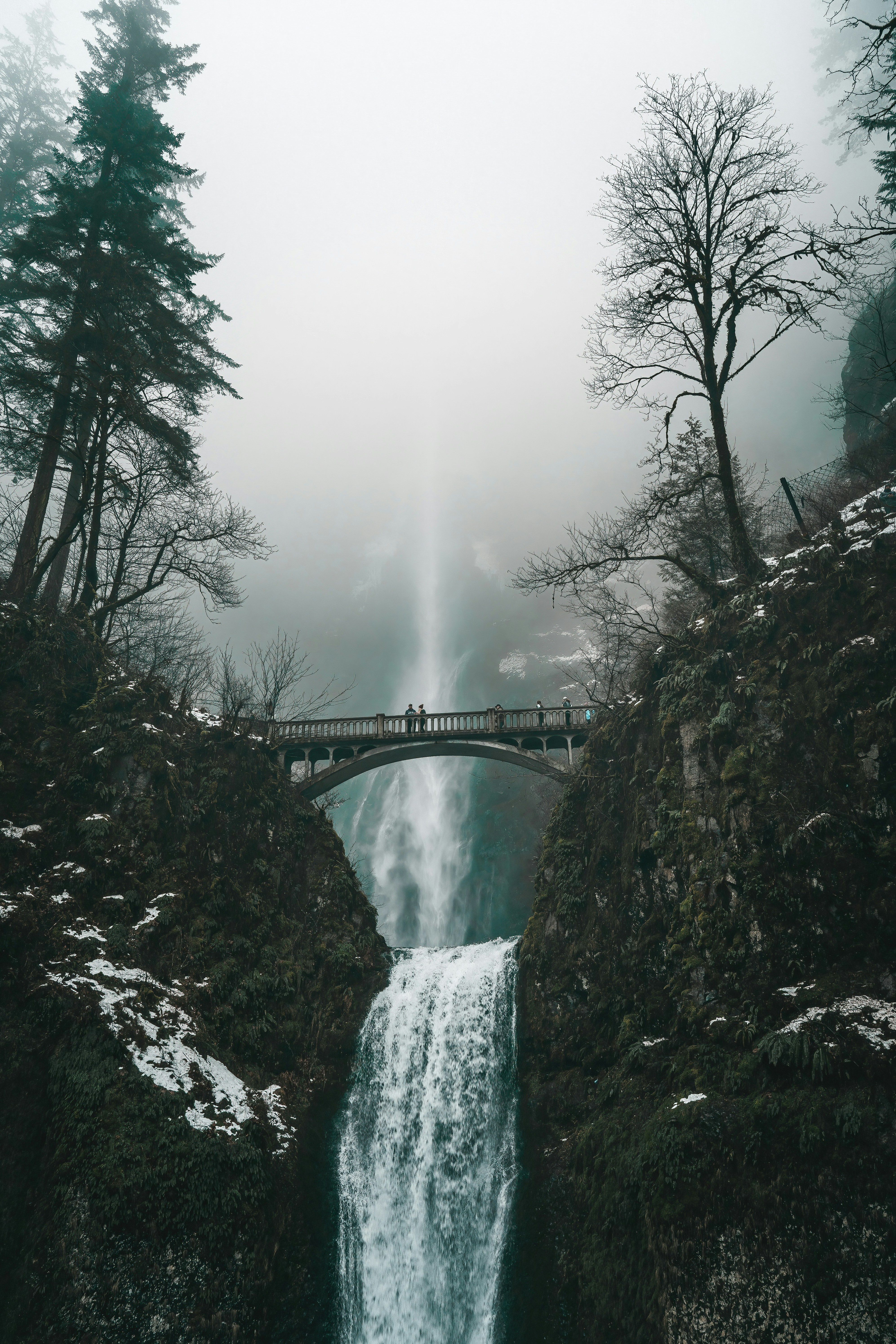 A waterfall with a bridge in the middle of it