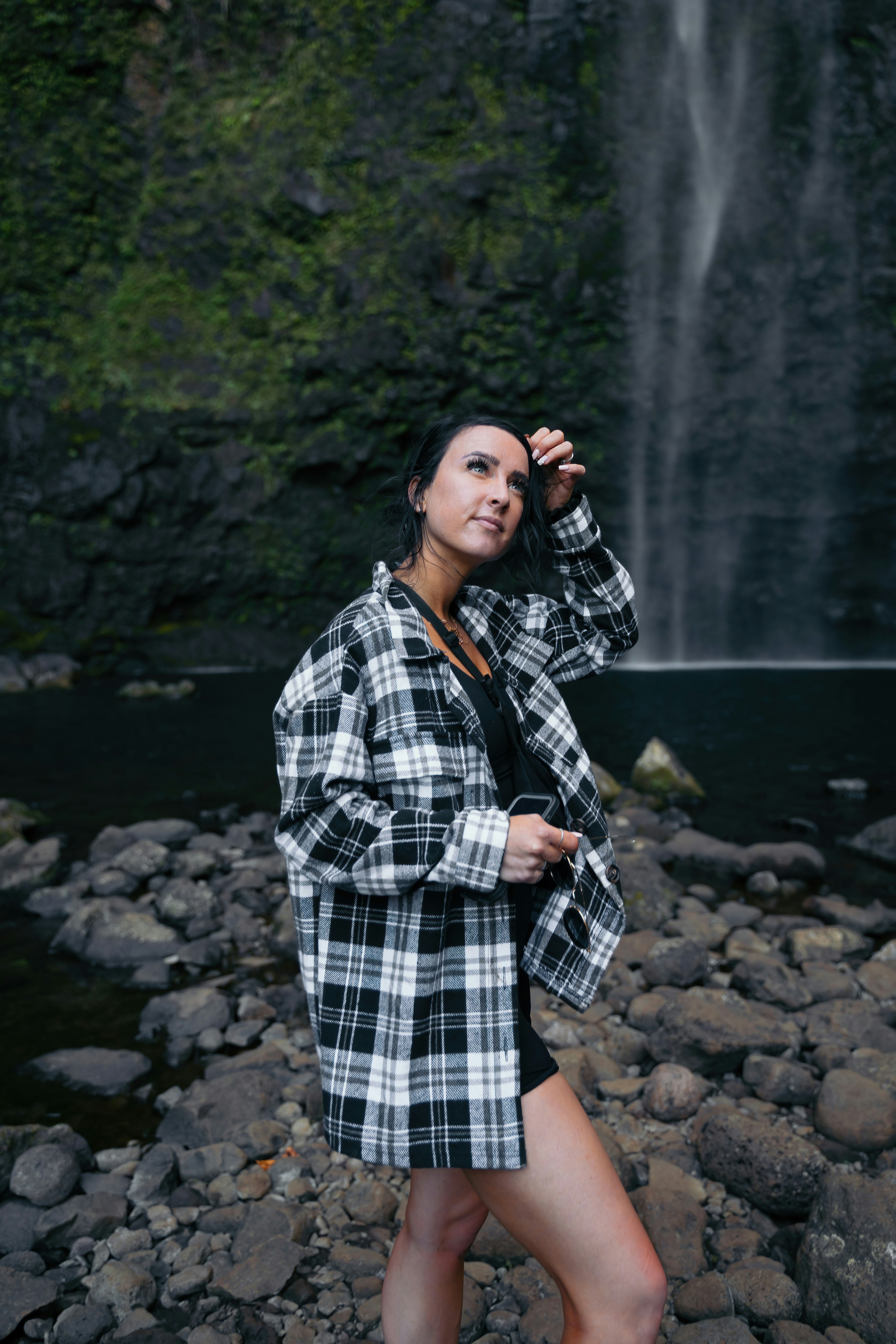 A woman standing in front of a waterfall