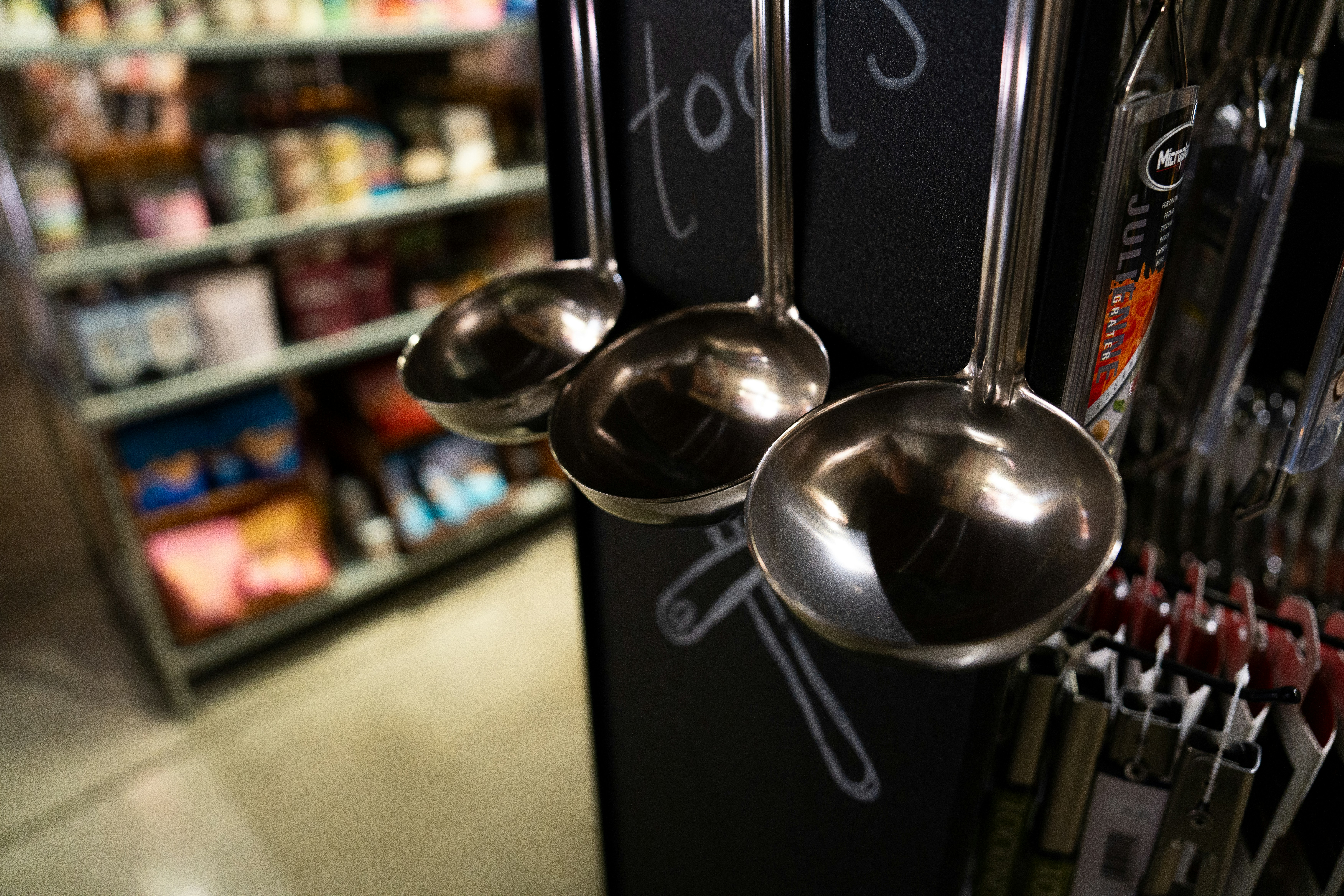 A row of metal spoons hanging from the side of a wall