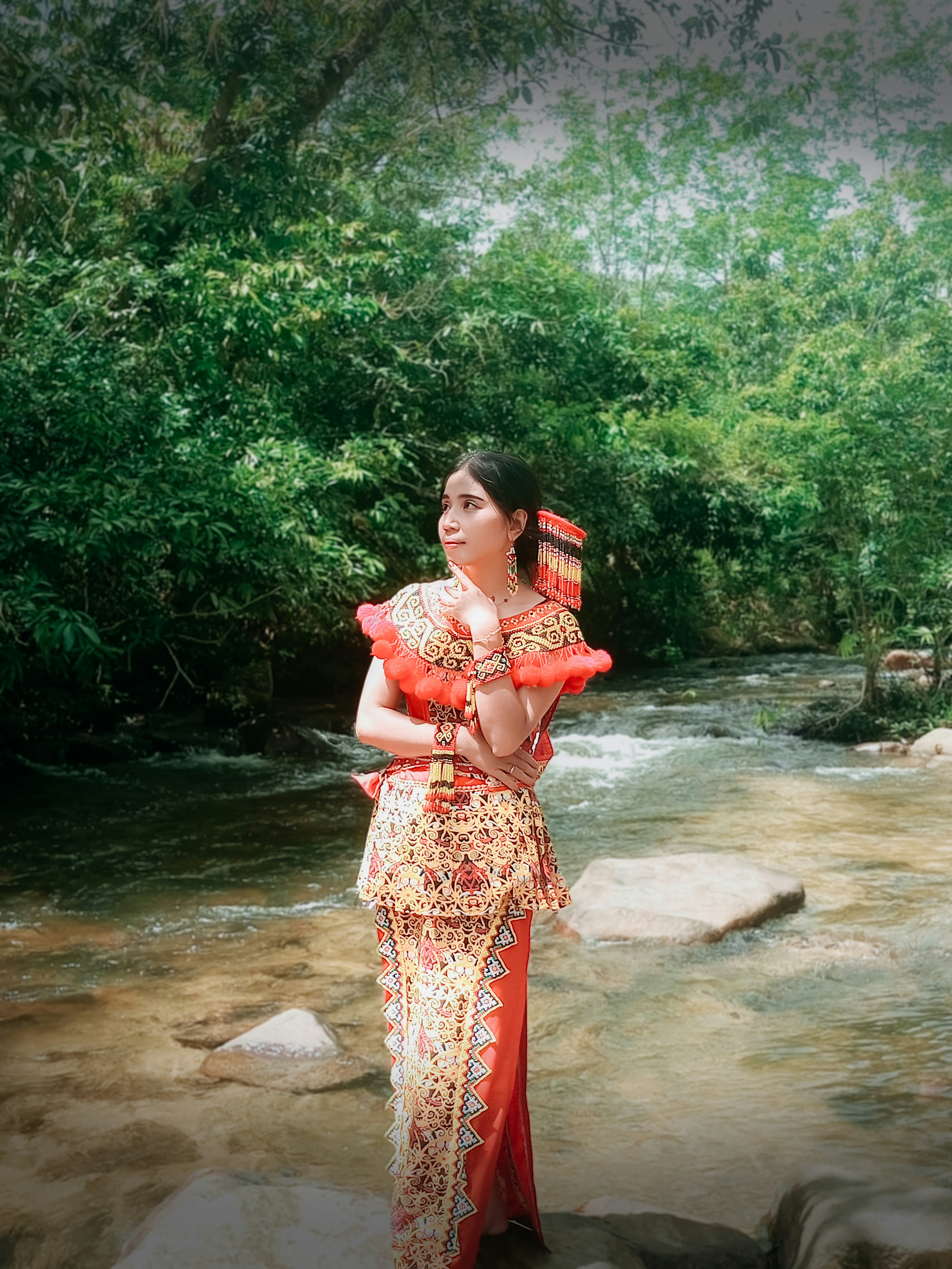 A woman in a red dress standing in a stream